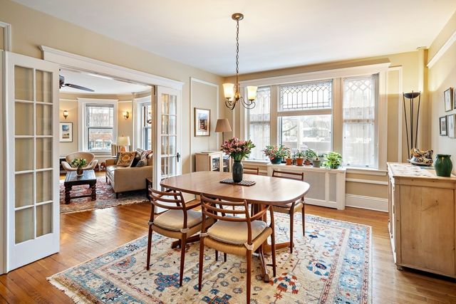 a dining room with furniture a chandelier and wooden floor