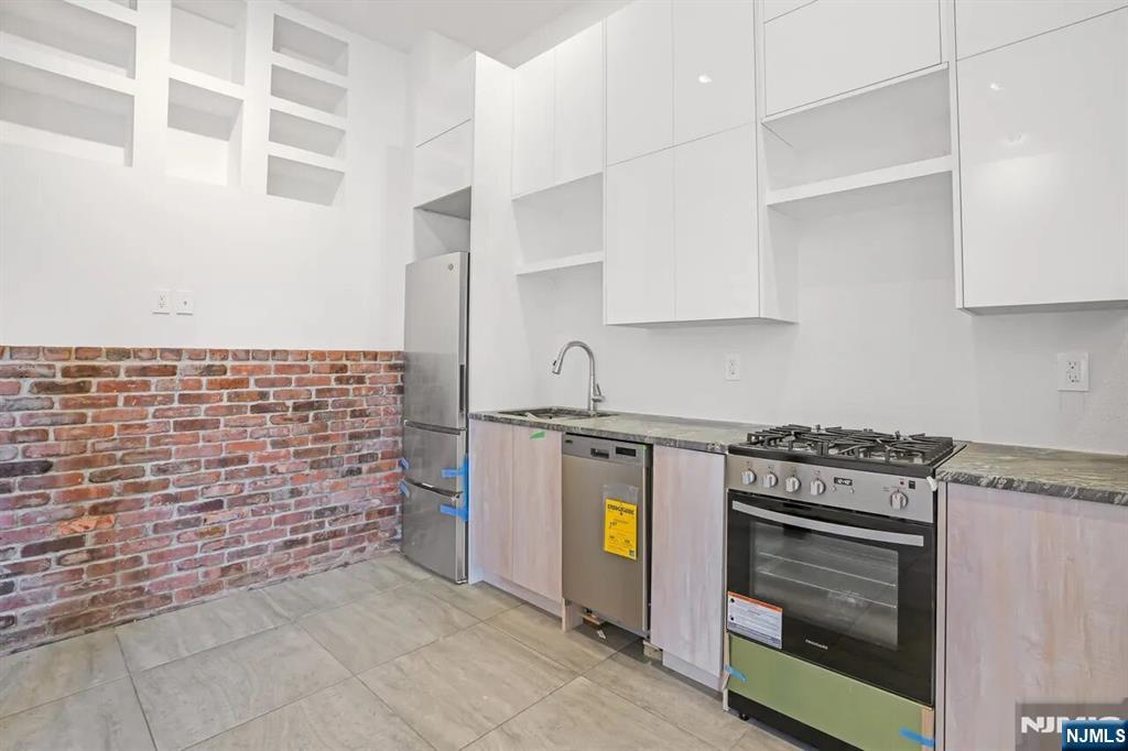 a kitchen with stainless steel appliances granite countertop a stove and a refrigerator