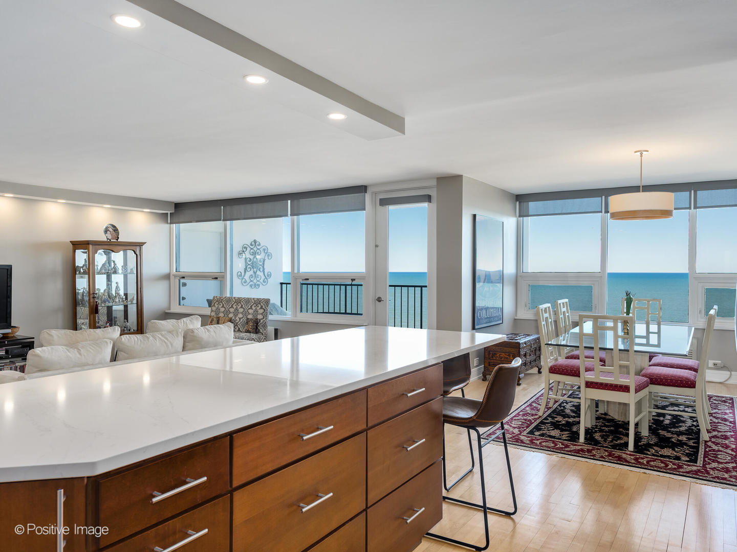 5733 North Sheridan Road, Unit 22C Chicago, IL 60660 - Photo 10 of 29 a kitchen with stainless steel appliances kitchen island granite countertop a table chairs in it and wooden floors