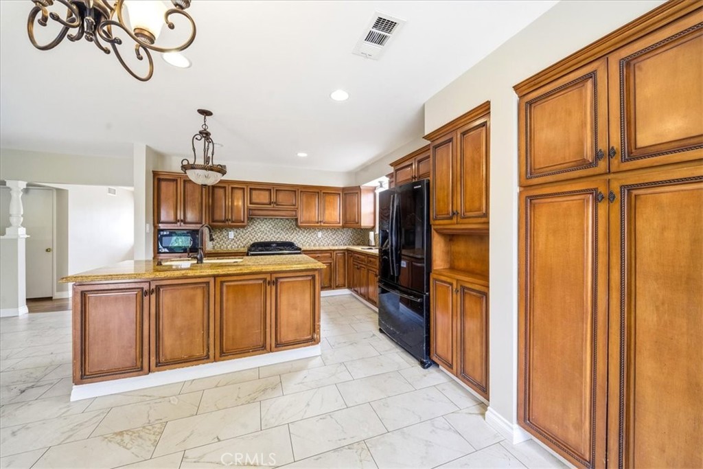 6481 Dos Rios Road Downey, CA 90240 - Photo 6 of 27 a kitchen with stainless steel appliances granite countertop a refrigerator and a sink