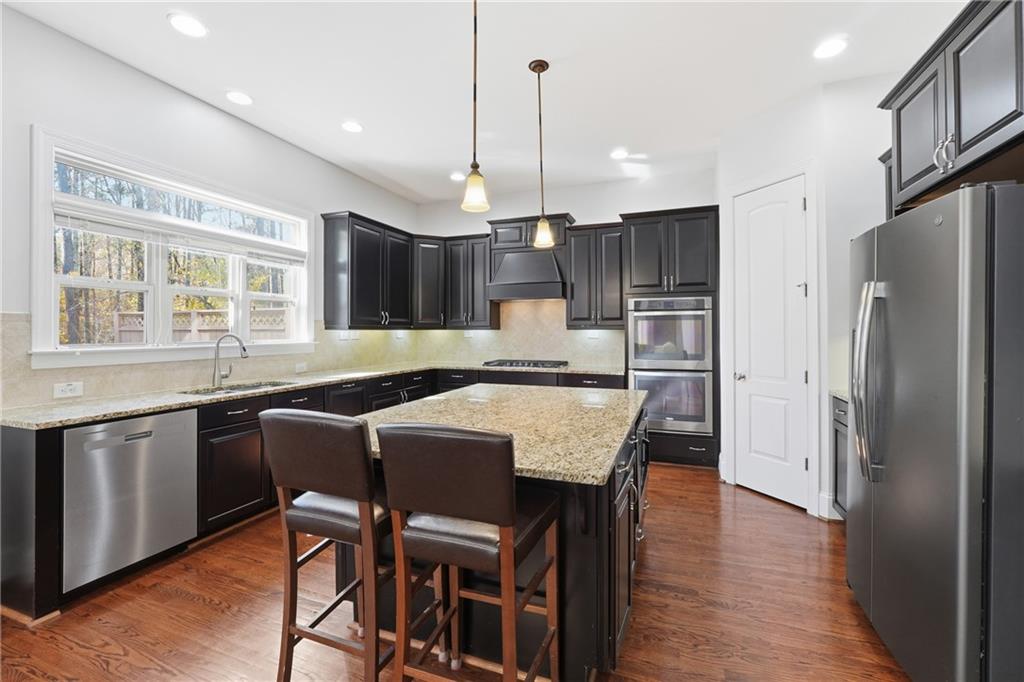 4409 Talisker Lane Acworth, GA 30101 - Photo 17 of 61 a kitchen with stainless steel appliances granite countertop a kitchen island hardwood floor and a sink
