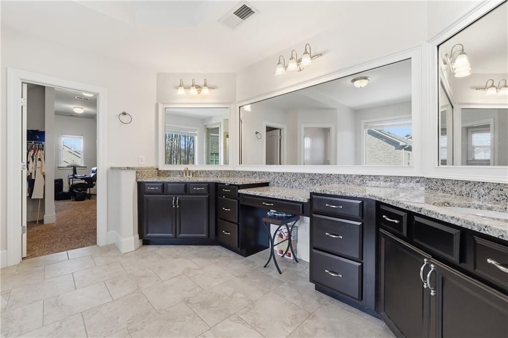 4409 Talisker Lane Acworth, GA 30101 - Photo 31 of 61 a spacious bathroom with a granite countertop sink and a mirror