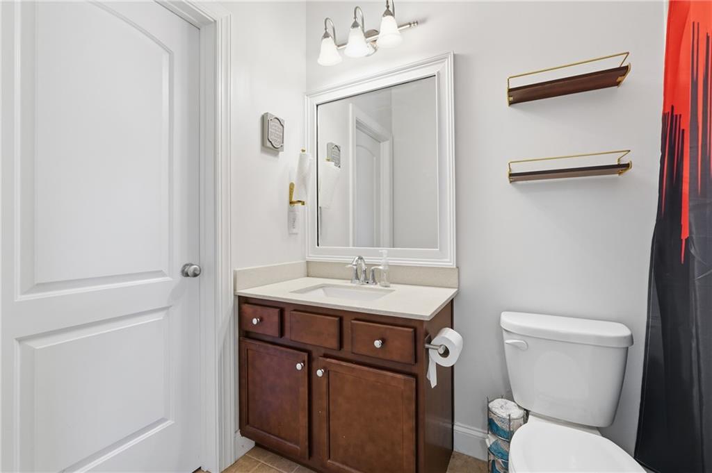 4409 Talisker Lane Acworth, GA 30101 - Photo 36 of 61 a bathroom with a toilet a sink and mirror