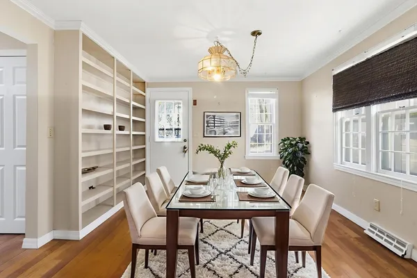 a dining room with furniture a chandelier and wooden floor
