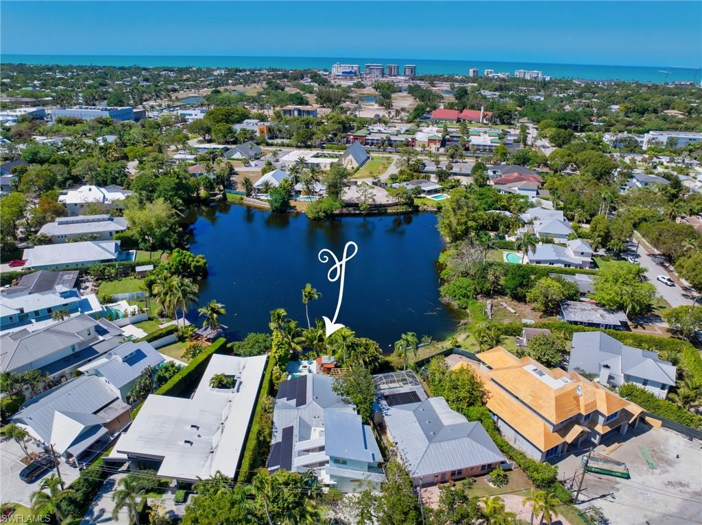 Aerial view of property and surrounding area with a large body of water and nearby suburban area