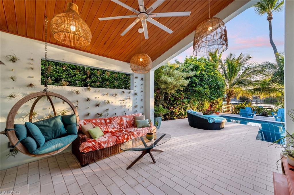 1155 12th Street North Naples, FL 34102 - Photo 13 of 18 Patio terrace at dusk with a ceiling fan, a patio area, and an outdoor pool