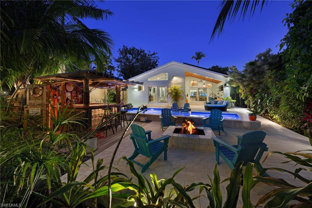 1155 12th Street North Naples, FL 34102 - Photo 2 of 18 Patio at night featuring a fire pit and a patio area