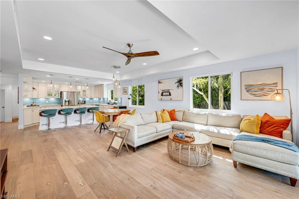 1155 12th Street North Naples, FL 34102 - Photo 7 of 18 Living room featuring a tray ceiling, a ceiling fan, plenty of natural light, light wood-style floors, and recessed lighting