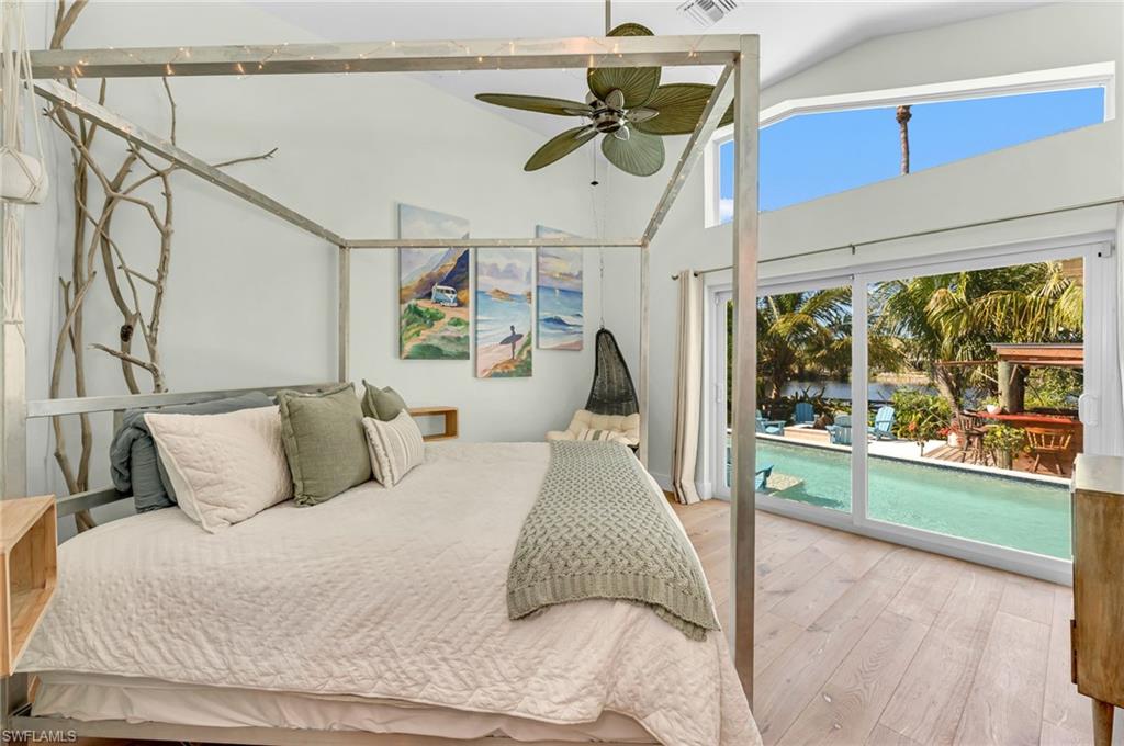 1155 12th Street North Naples, FL 34102 - Photo 10 of 18 Bedroom featuring light wood finished floors, access to exterior, lofted ceiling, ceiling fan, and a water view