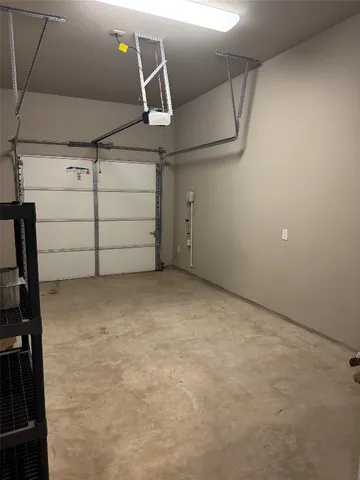 a view of an empty room with wooden floor and a ceiling fan