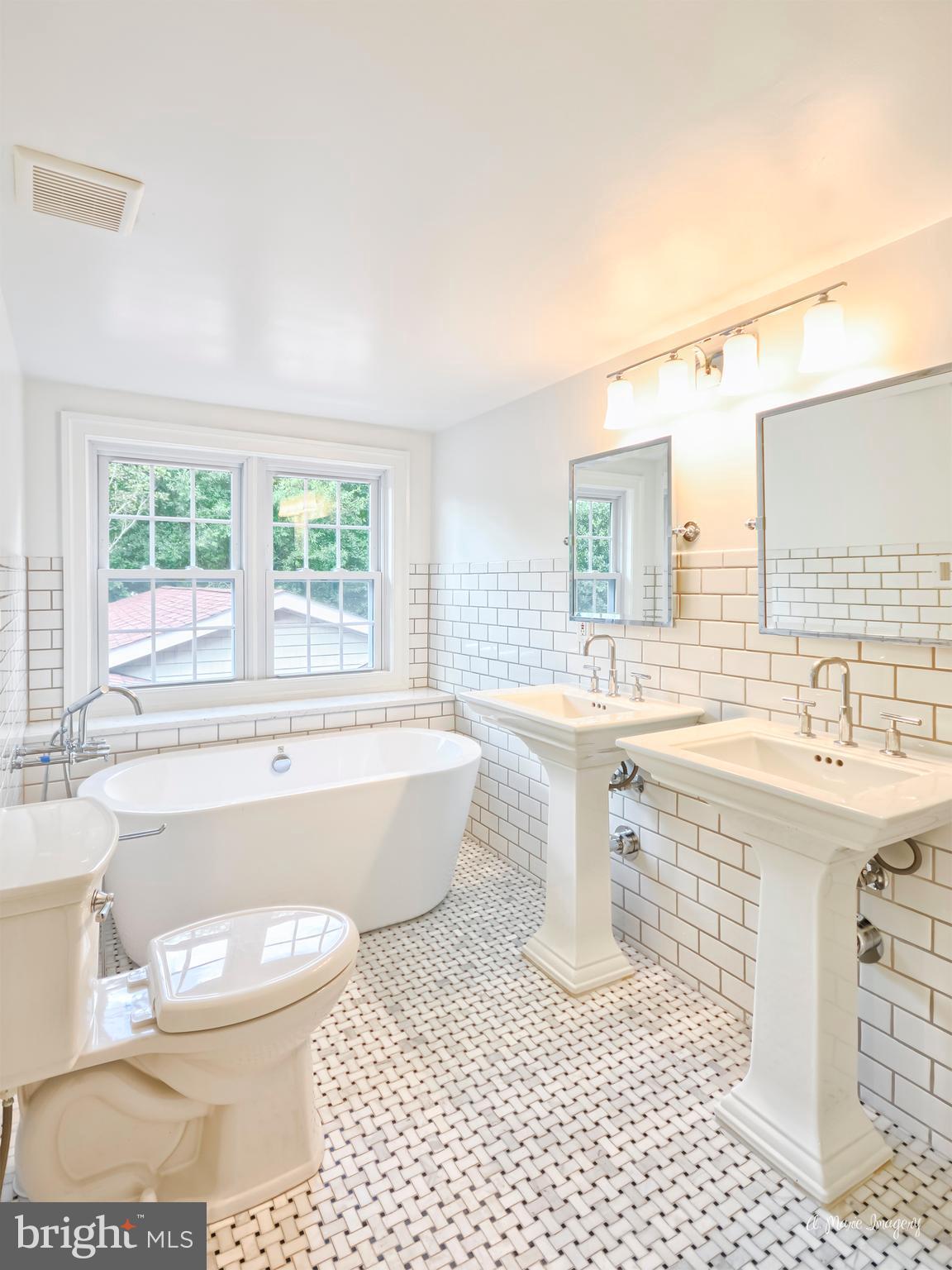 8744 Yellow Springs Road Frederick, MD 21702 - Photo 22 of 30 a bathroom with a sink a bathtub a mirror a toilet a window and vanity