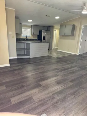 a view of a kitchen with a sink and dishwasher a oven with wooden floor