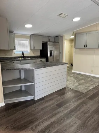 a view of a kitchen with wooden floor and electronic appliances