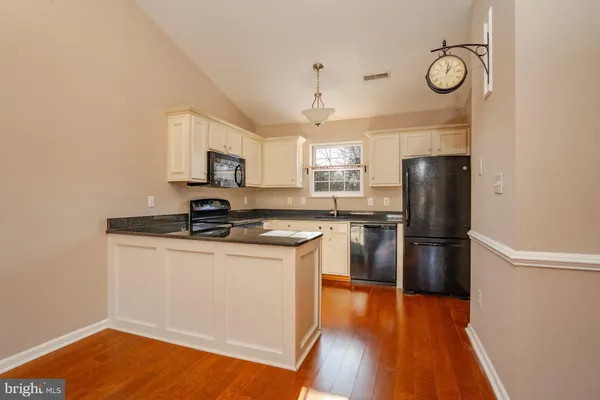 a kitchen with a refrigerator sink and cabinets