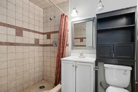 a bathroom with a sink a toilet and shower