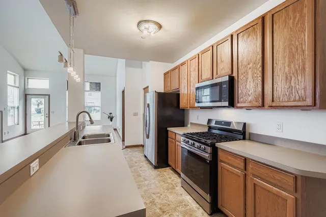 a kitchen with stainless steel appliances granite countertop a refrigerator stove and sink