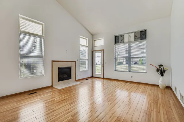 wooden floor fireplace and windows in an empty room