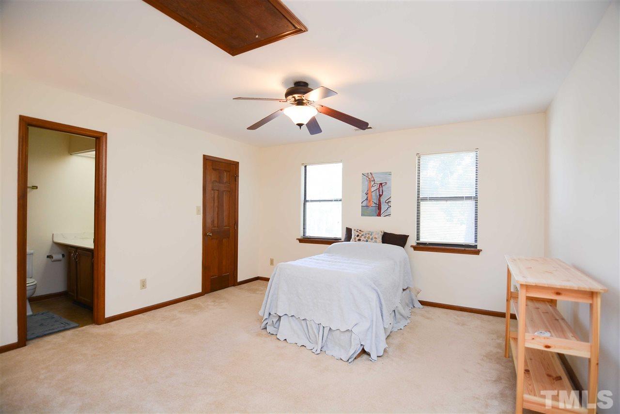 5433 Pine Top Circle Raleigh, NC 27612 - Photo 15 of 23 a bedroom with a bed and a chandelier