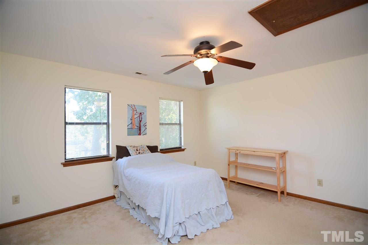 5433 Pine Top Circle Raleigh, NC 27612 - Photo 16 of 23 a bedroom with a large bed and a chandelier fan