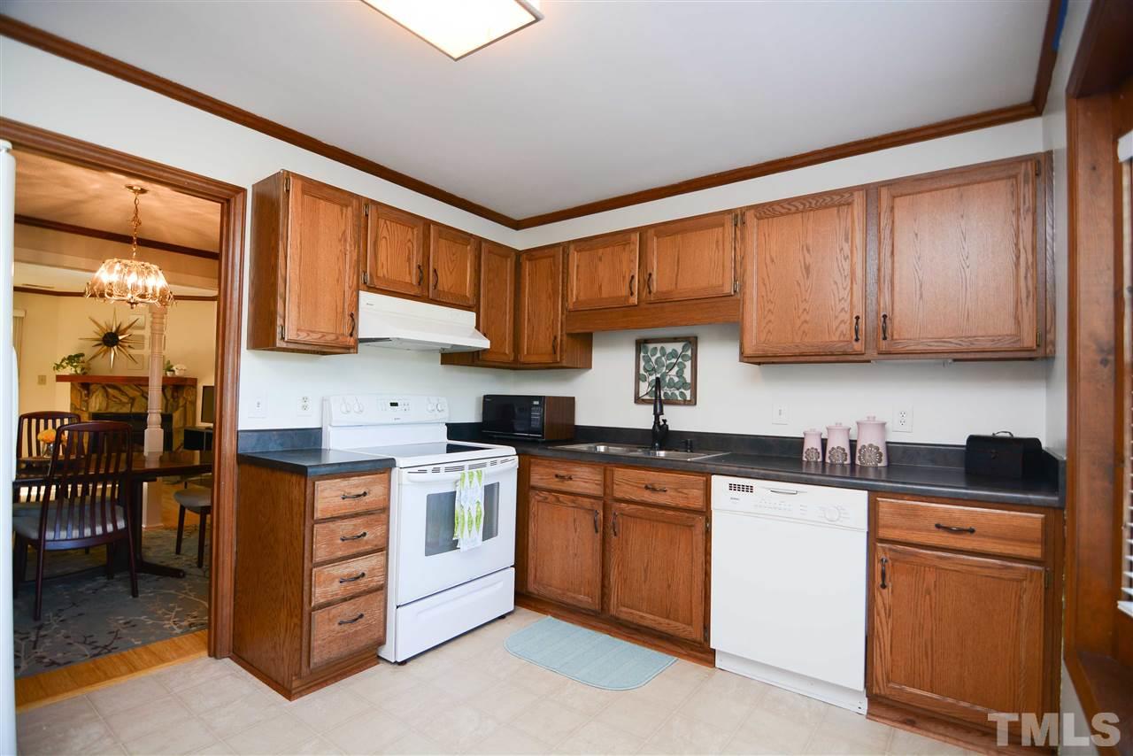 5433 Pine Top Circle Raleigh, NC 27612 - Photo 7 of 23 a kitchen with stainless steel appliances granite countertop a stove top oven a sink dishwasher and cabinets with wooden floor