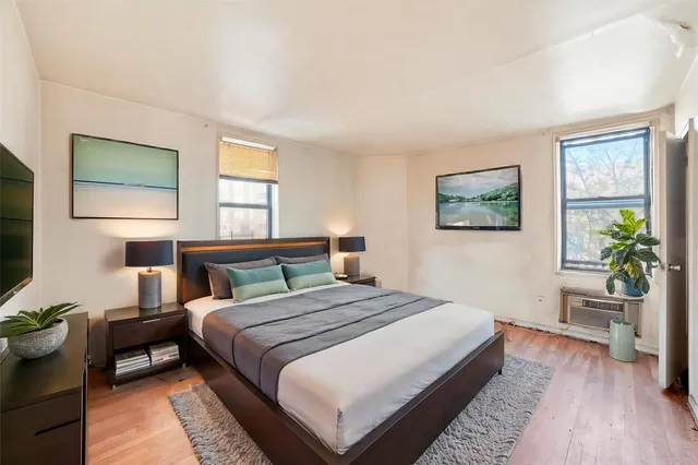 an empty room with a hardwood and windows