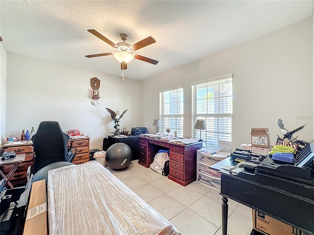1511 Tiger Tooth Place Ruskin, FL 33570 - Photo 15 of 59 a bedroom with a bed and a chandelier