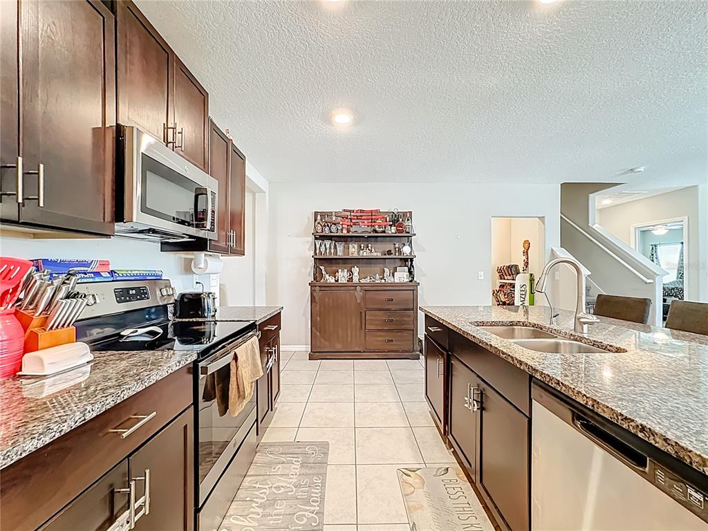 1511 Tiger Tooth Place Ruskin, FL 33570 - Photo 20 of 59 a kitchen with stainless steel appliances granite countertop a sink stove and refrigerator