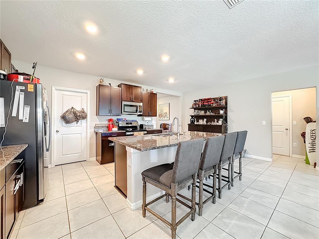1511 Tiger Tooth Place Ruskin, FL 33570 - Photo 21 of 59 a kitchen with stainless steel appliances a refrigerator sink and microwave