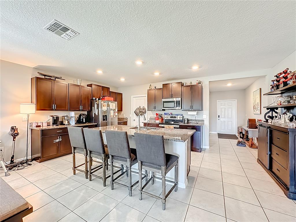 1511 Tiger Tooth Place Ruskin, FL 33570 - Photo 23 of 59 a kitchen with stainless steel appliances kitchen island granite countertop a sink and cabinets
