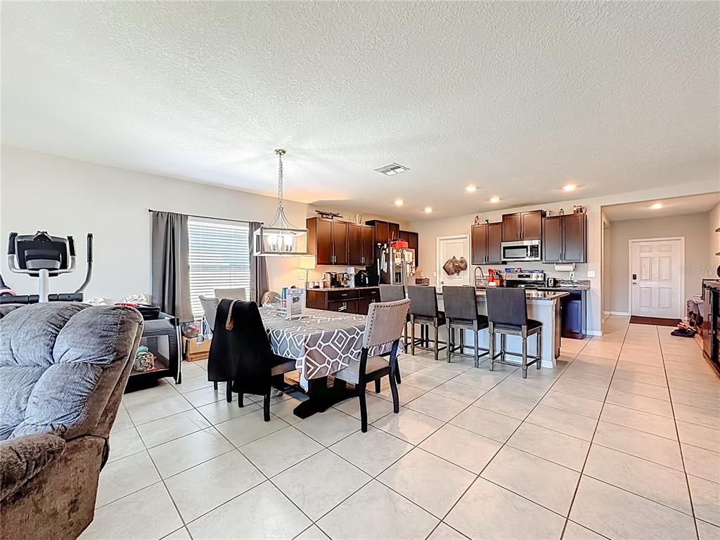 1511 Tiger Tooth Place Ruskin, FL 33570 - Photo 27 of 59 a living room with furniture and a dining table with kitchen view