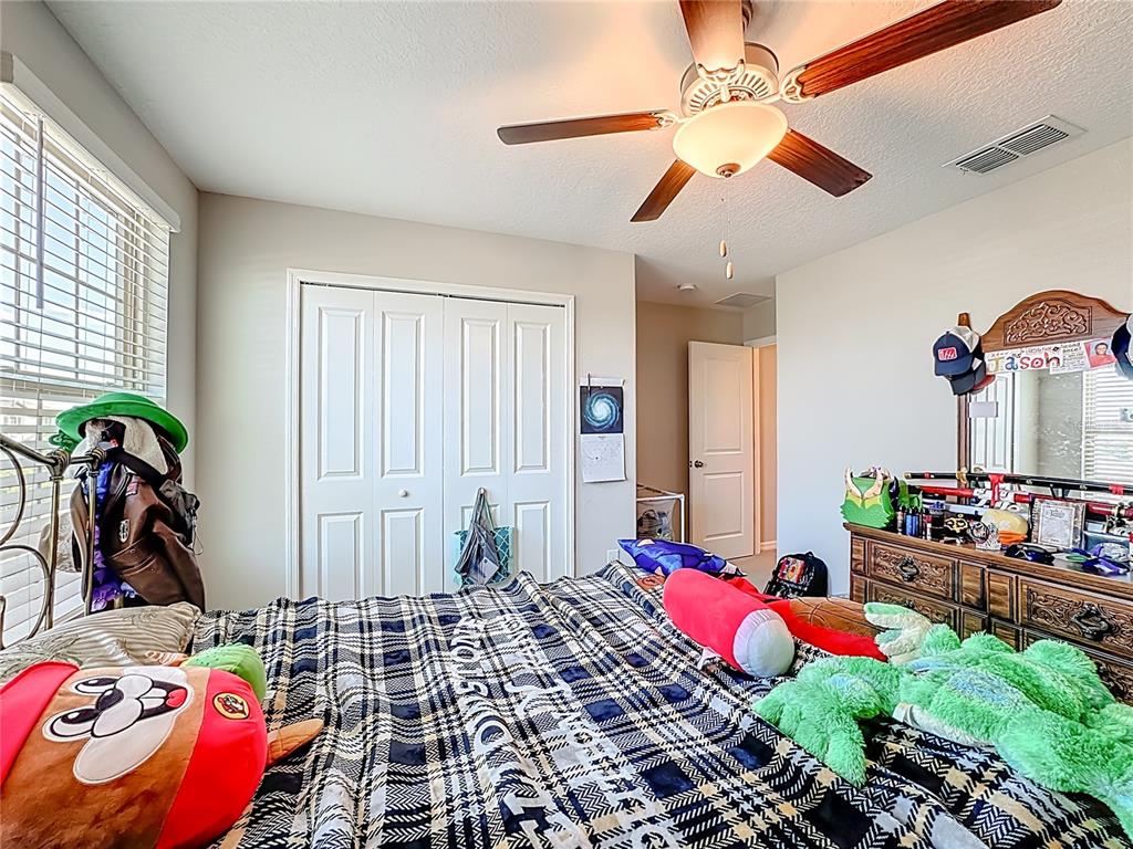 1511 Tiger Tooth Place Ruskin, FL 33570 - Photo 32 of 59 a bedroom with furniture and a chandelier