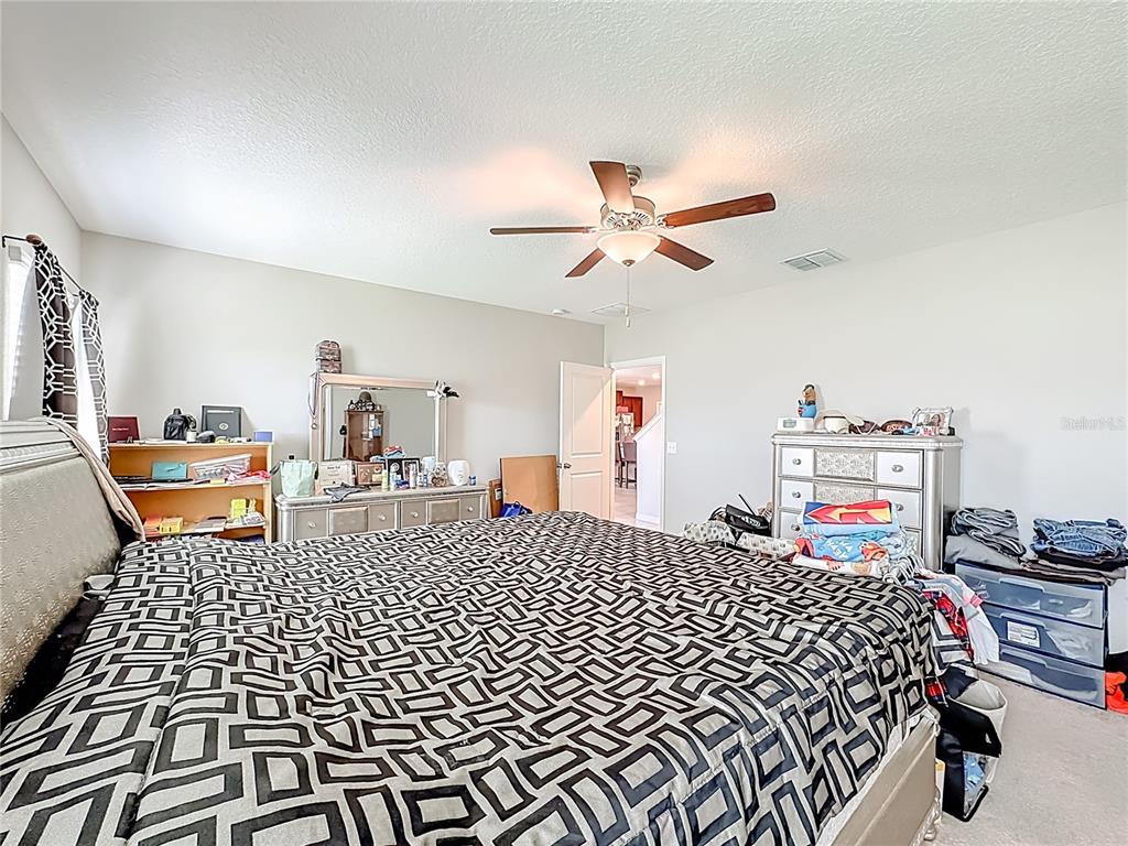 1511 Tiger Tooth Place Ruskin, FL 33570 - Photo 34 of 59 a bedroom with a bed and dresser