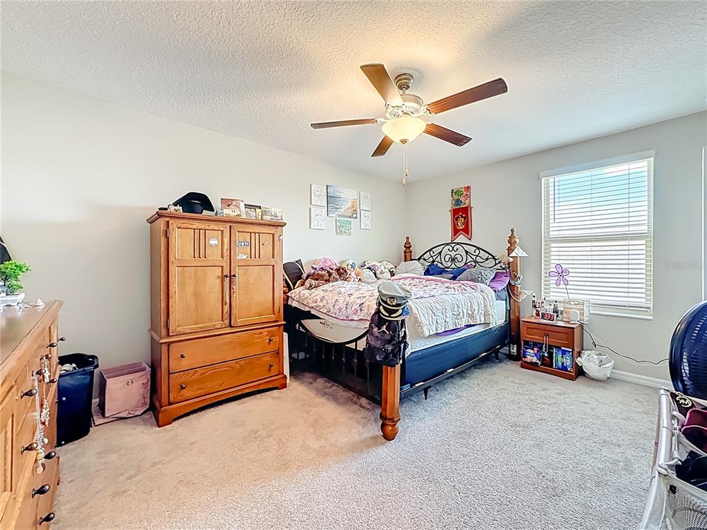 1511 Tiger Tooth Place Ruskin, FL 33570 - Photo 44 of 59 a bedroom with a bed and a chandelier