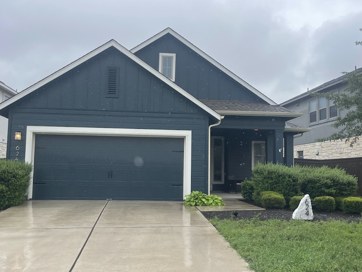 Contemporary exterior with a two-car garage, covered entry porch, and white trim accents