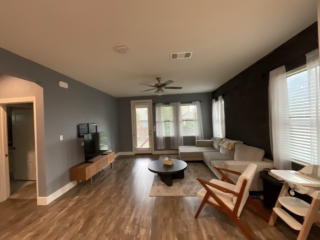 624 Golden Glory Road Leander, TX 78641 - Photo 11 of 39 Spacious living area featuring wood-finish flooring, a ceiling fan, and multiple windows with blinds