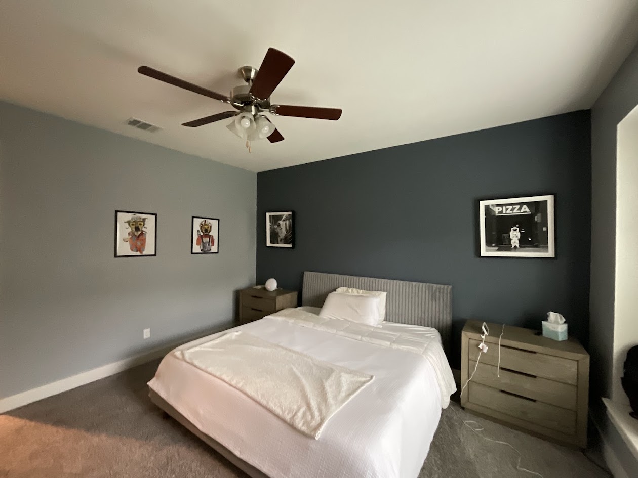 624 Golden Glory Road Leander, TX 78641 - Photo 19 of 39 Bedroom featuring a ceiling fan with integrated lighting, contrasting accent wall, and neutral-toned carpeting