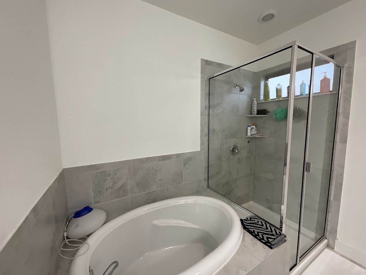 624 Golden Glory Road Leander, TX 78641 - Photo 20 of 39 Contemporary bathroom featuring a freestanding soaking tub and a glass-enclosed shower