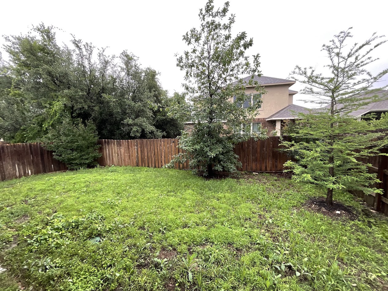 624 Golden Glory Road Leander, TX 78641 - Photo 29 of 39 Spacious backyard featuring a wooden privacy fence, mature perimeter trees, and a two-story home visible in the background