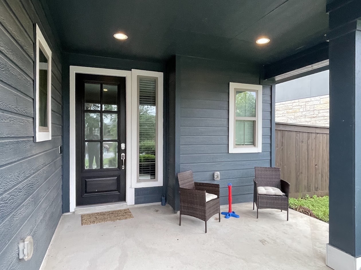 624 Golden Glory Road Leander, TX 78641 - Photo 3 of 39 Covered concrete porch with dark blue siding and a black front door featuring clear glass panels and white trim