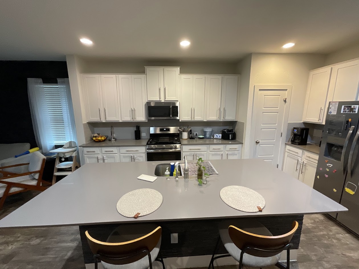 624 Golden Glory Road Leander, TX 78641 - Photo 6 of 39 Spacious kitchen featuring a large island, stainless steel appliances, ample white cabinetry, sleek countertops, and recessed lighting
