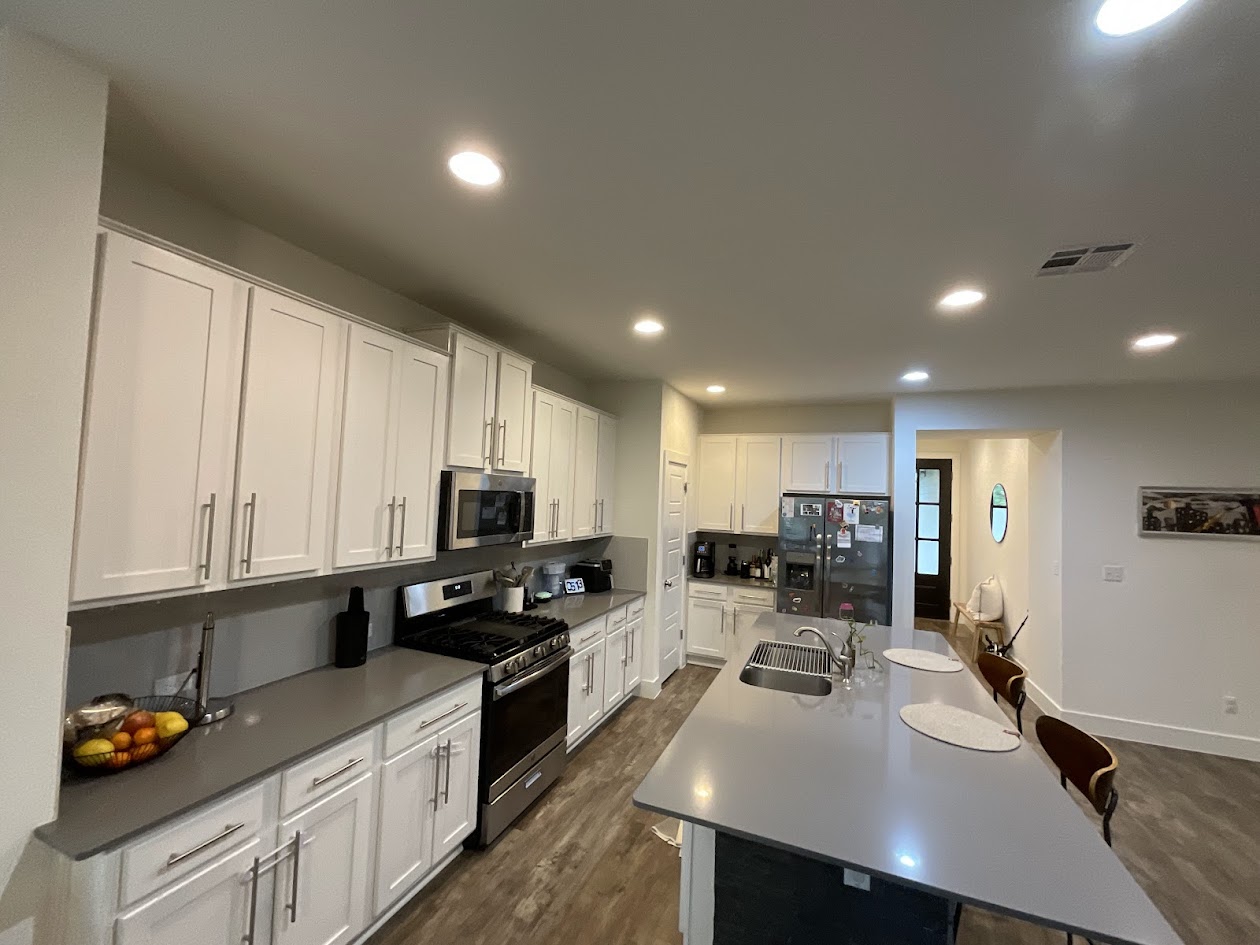 624 Golden Glory Road Leander, TX 78641 - Photo 8 of 39 Kitchen featuring extensive white cabinetry, stainless steel appliances, dark gray countertops, and wood-finish flooring