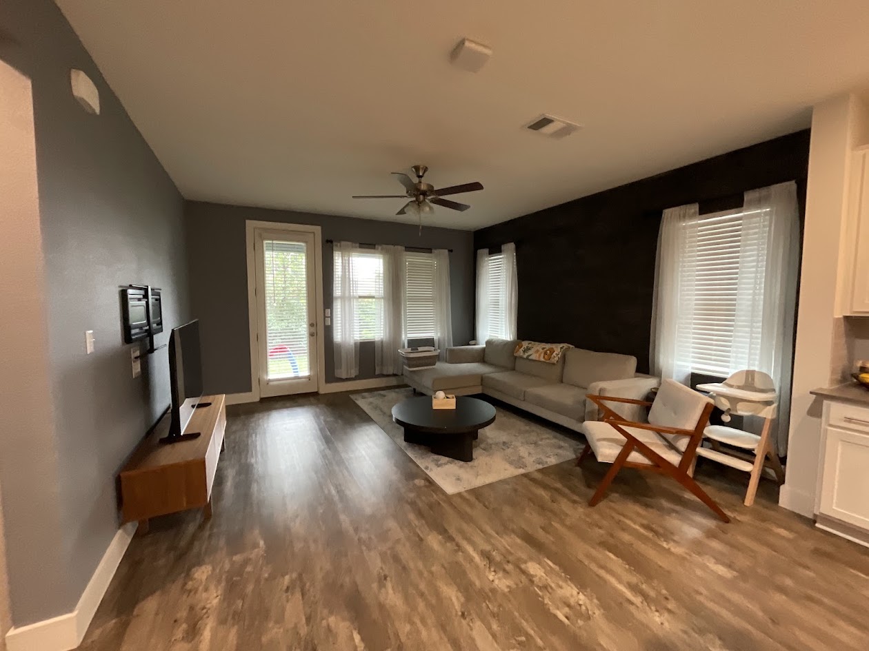 624 Golden Glory Road Leander, TX 78641 - Photo 10 of 39 Spacious living area featuring wood-finish flooring, a ceiling fan with integrated lighting, and multiple windows with blinds