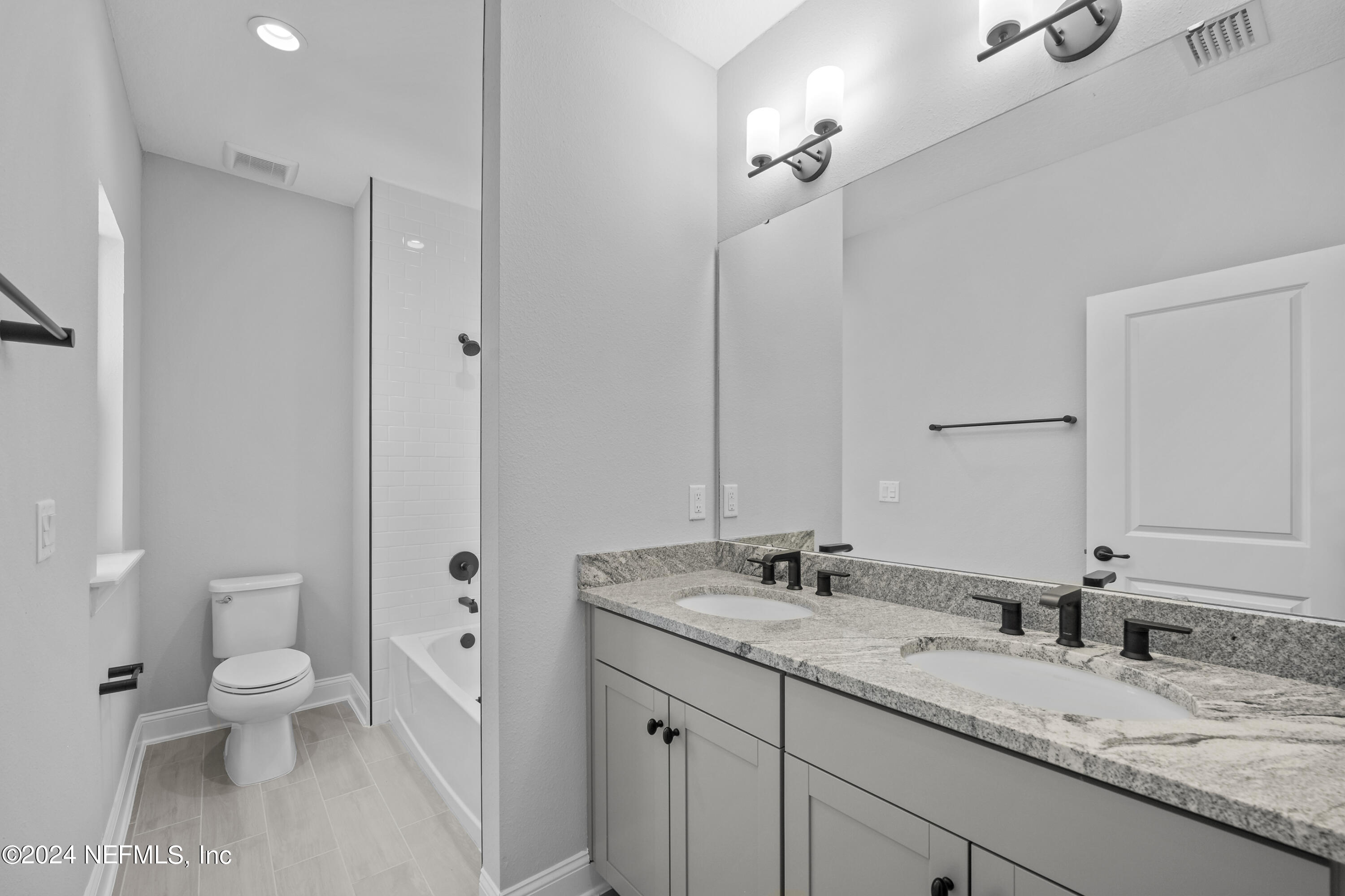 27 Oak Pk Drive St. Johns, FL 32259 - Photo 38 of 71 a bathroom with a granite countertop sink a toilet and a mirror