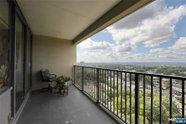 a balcony with chairs and wooden fence