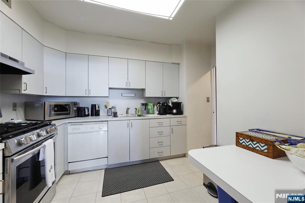 6 Horizon Road, Unit 2106 Fort Lee, NJ 07024 - Photo 4 of 20 a kitchen with stainless steel appliances granite countertop a sink dishwasher stove top oven and cabinets