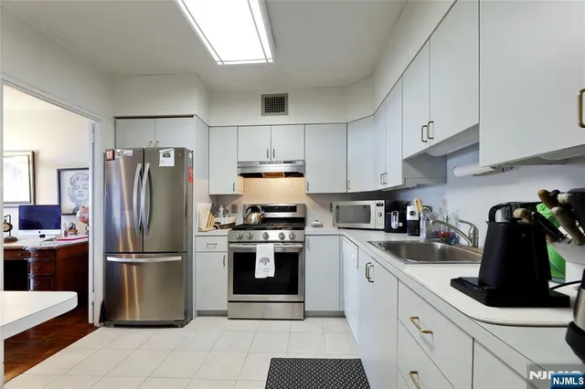a kitchen with a refrigerator sink and cabinets