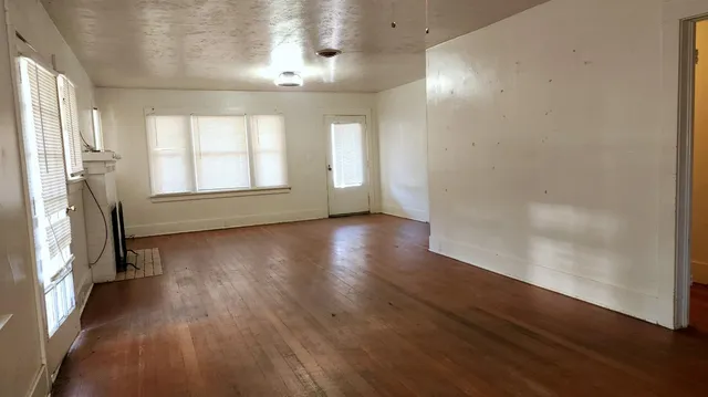 a view of an empty room with window and closet area