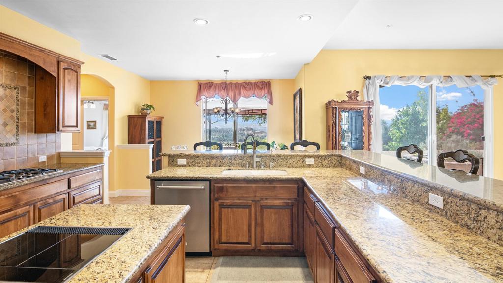 40487 Rock Mountain Drive Fallbrook, CA 92028 - Photo 13 of 57 a large kitchen with a large counter top a sink stainless steel appliances and cabinets