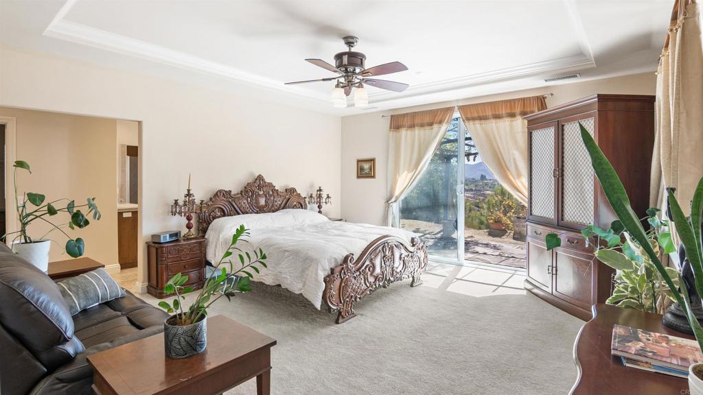 40487 Rock Mountain Drive Fallbrook, CA 92028 - Photo 22 of 57 a bedroom with a bed and a chandelier