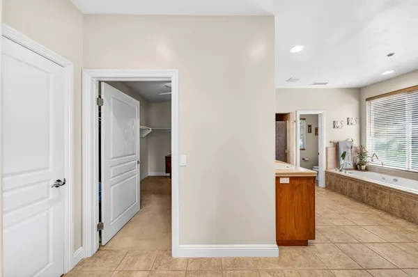a view of a hallway to a livingroom with wooden floor and cabinet